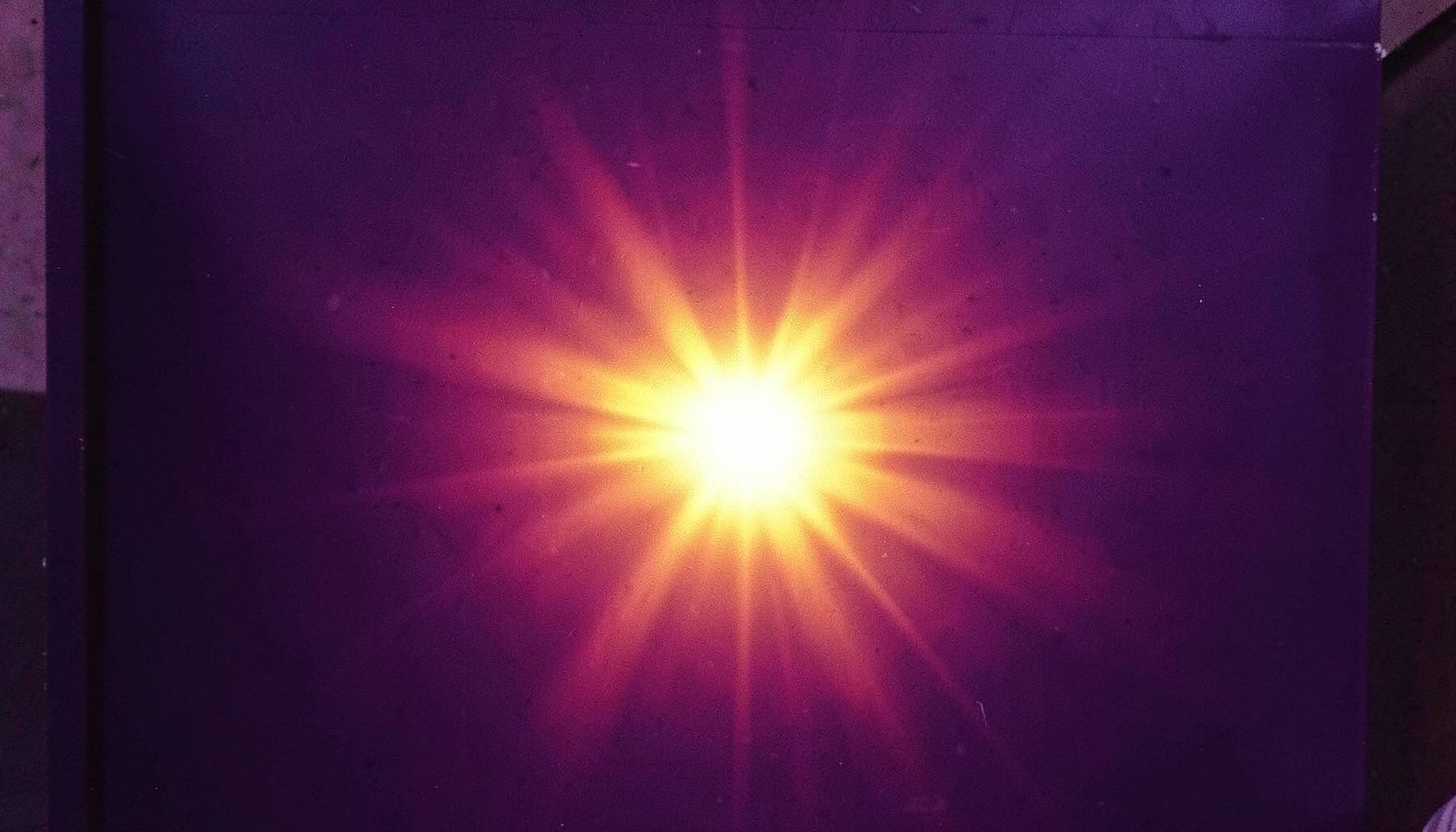 Dark purple panel with a warm golden-orange glow radiating from the center, suggesting energy and focus